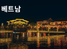 베트남 호이안의 야경, 금빛 조명과 강물에 비친 전통 건축물 전경